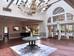 Elegant room with chandelier and piano.