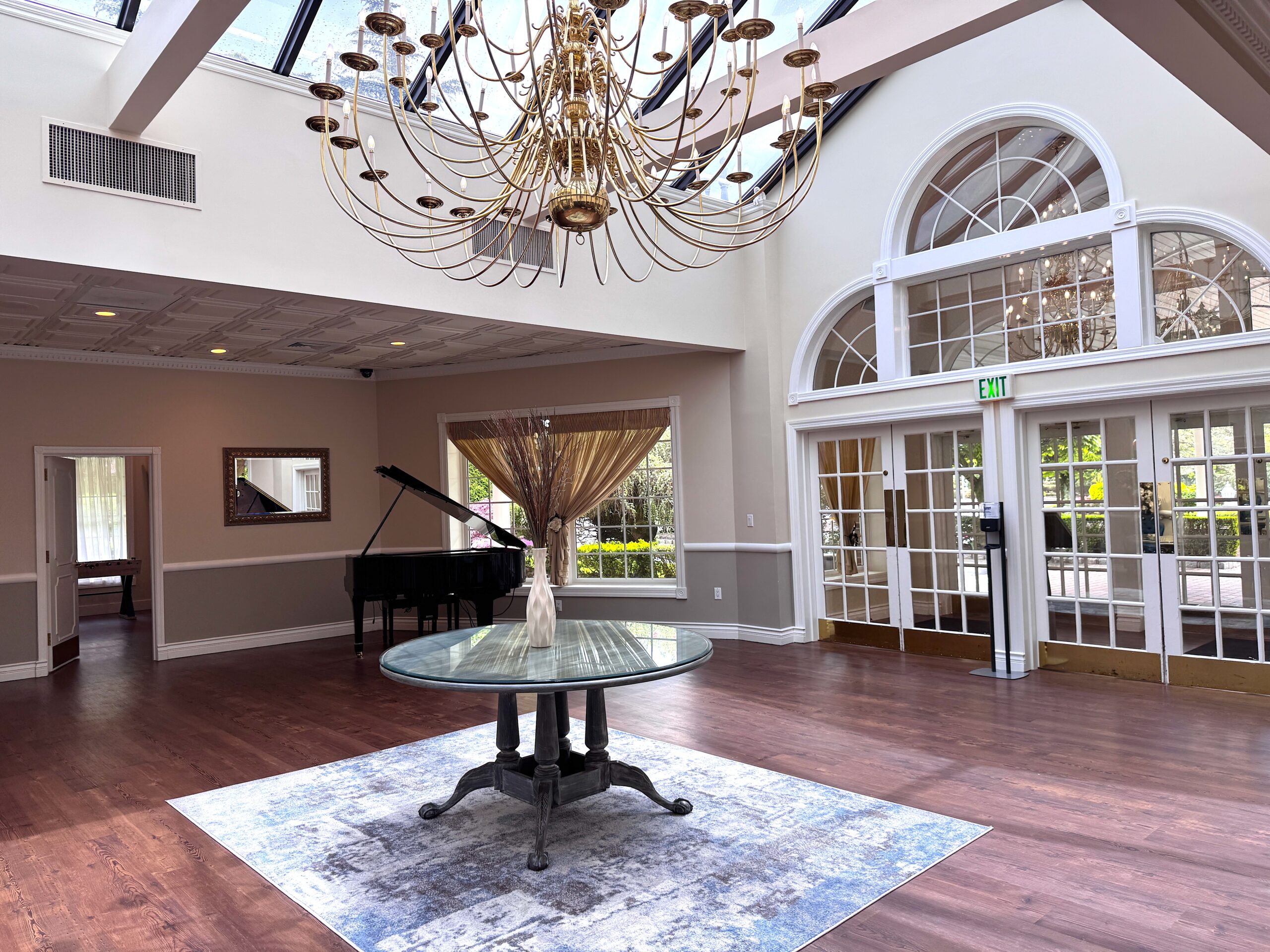 Elegant room with chandelier and piano.