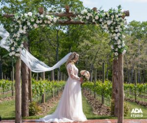 bride under wedding arches with veil in air THOMAS & JACLYN 05-21-22_TS6_0523 LR