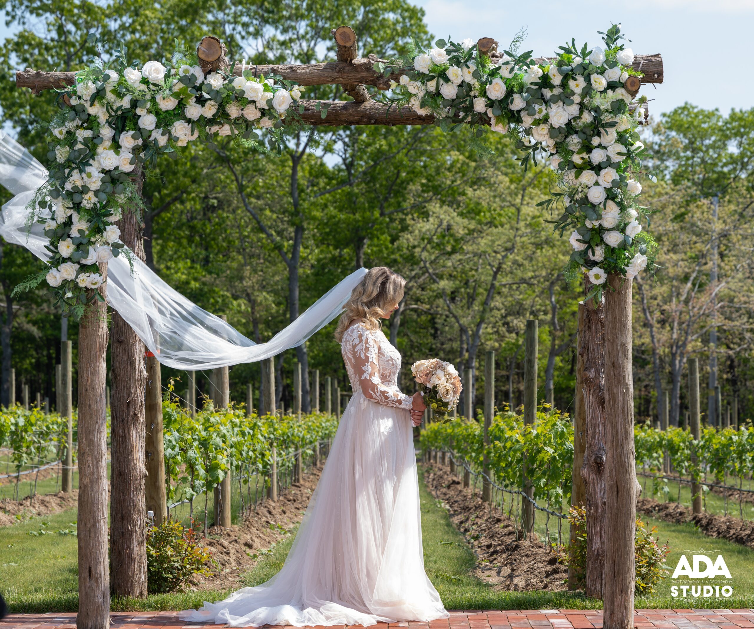 bride under wedding arches with veil in air THOMAS & JACLYN 05-21-22_TS6_0523 LR