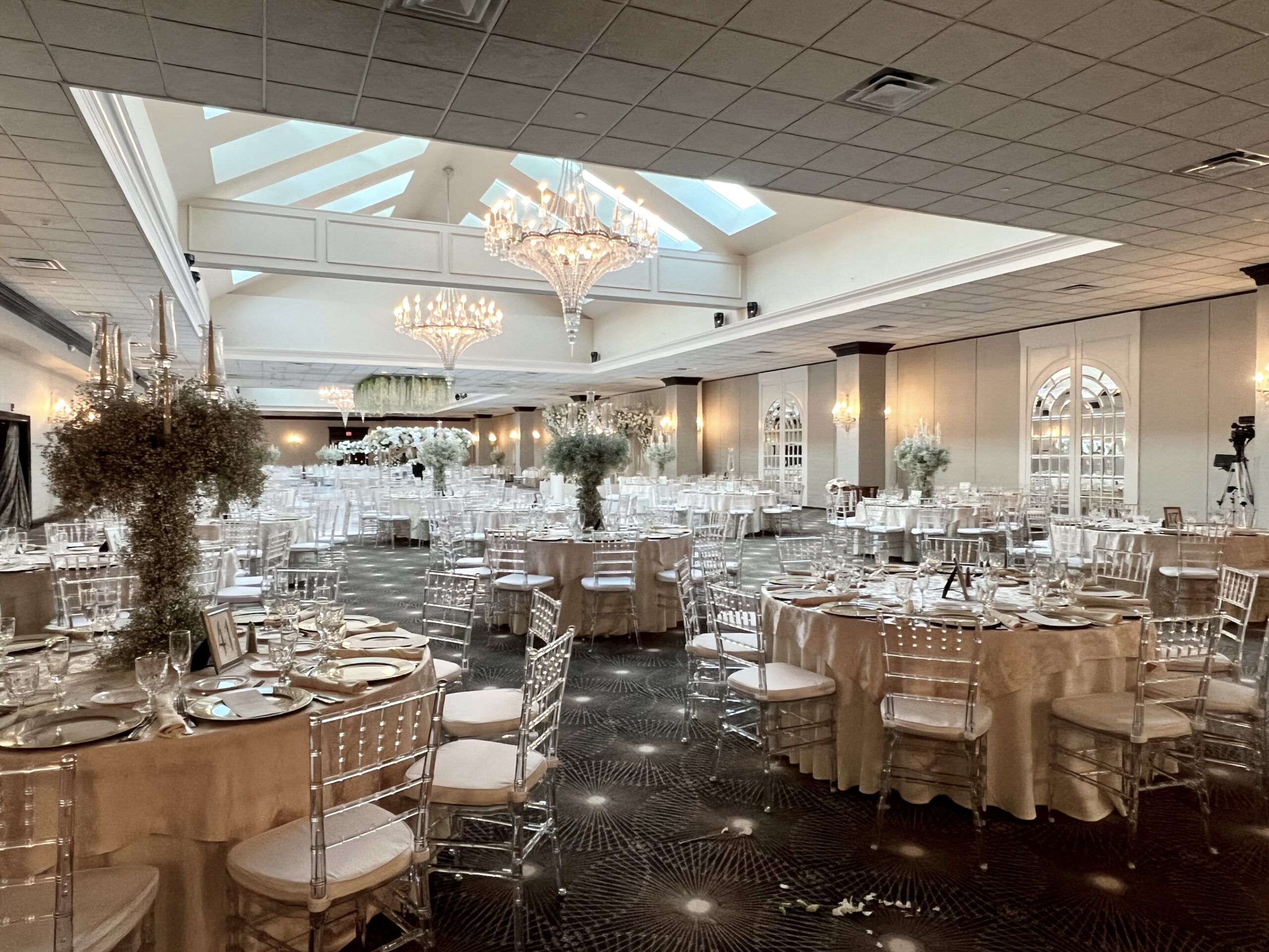 Elegant banquet hall with chandeliers and decor.