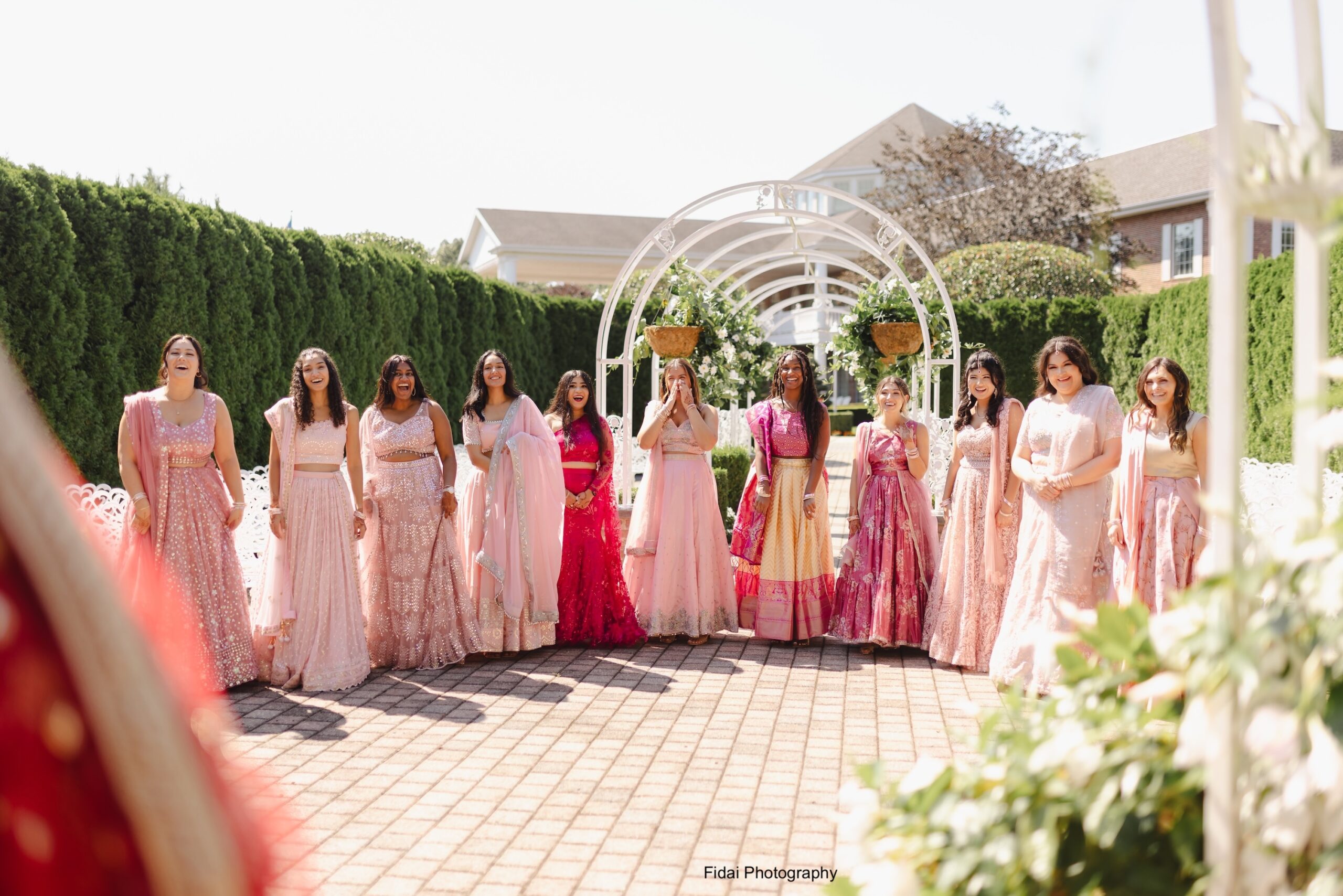 Bridesmaids in pink dresses celebrating outdoors.