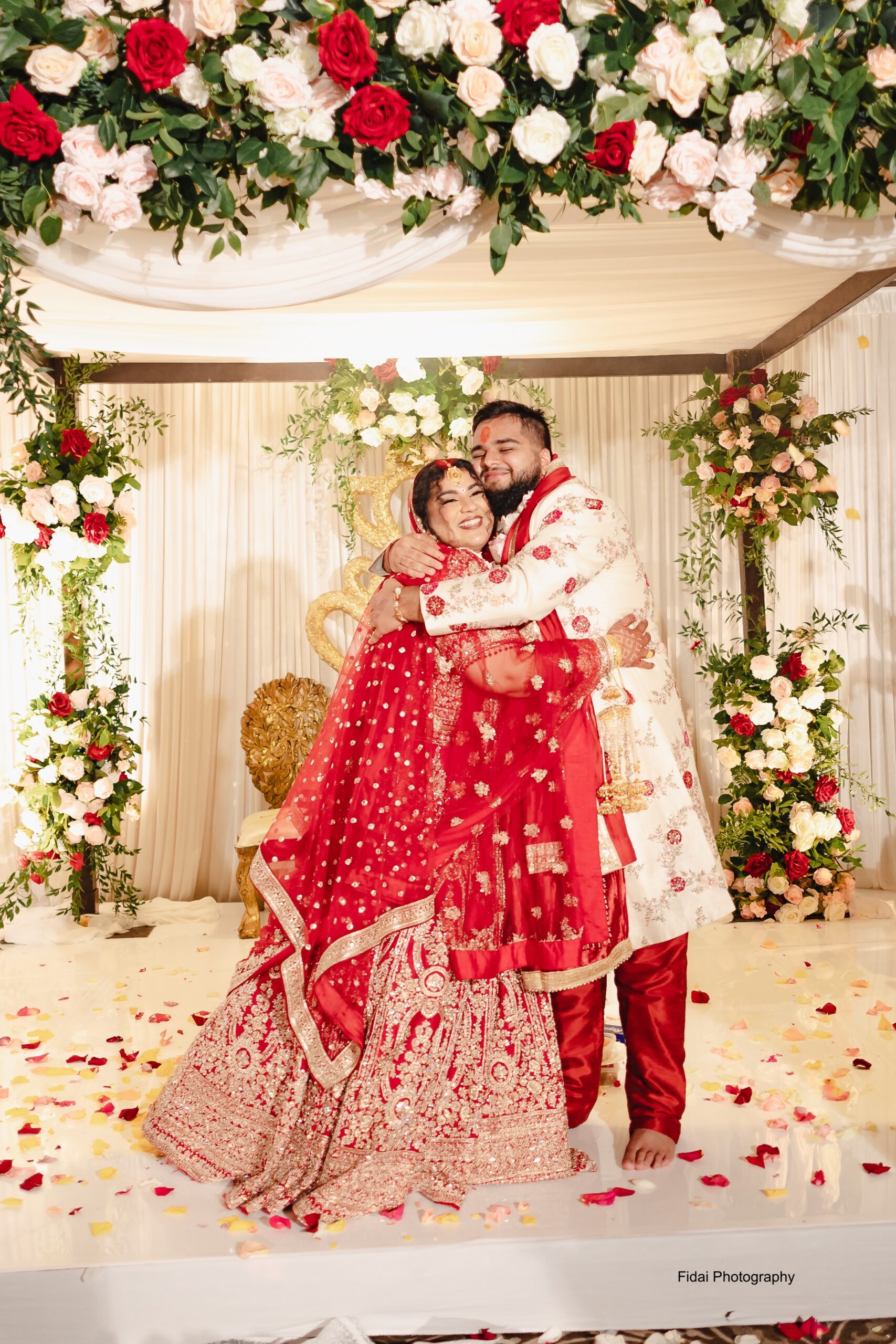 Happy couple embracing in vibrant wedding attire.