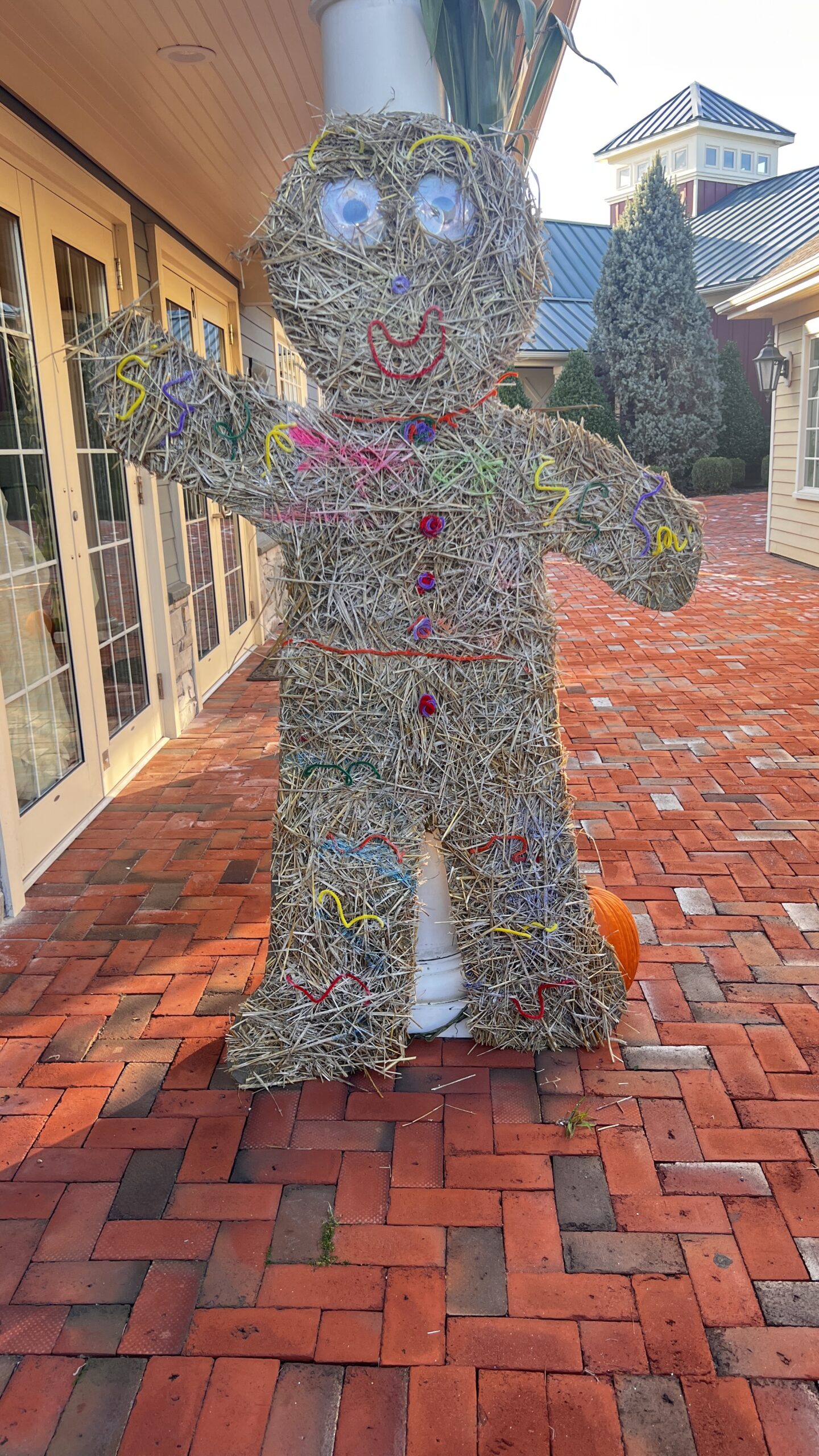 Hay figure decoration on a brick patio.
