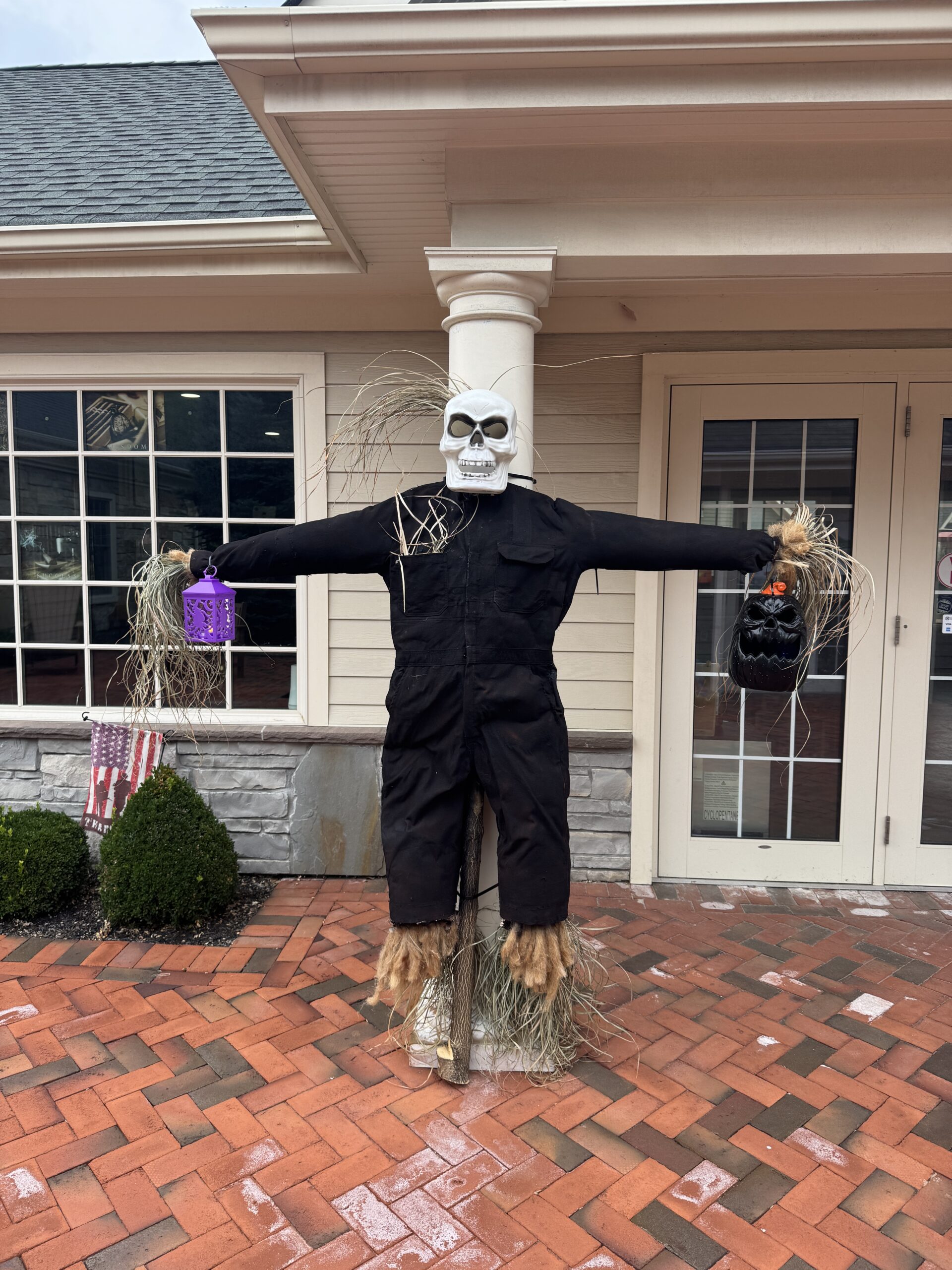 Halloween scarecrow decoration outside a building.