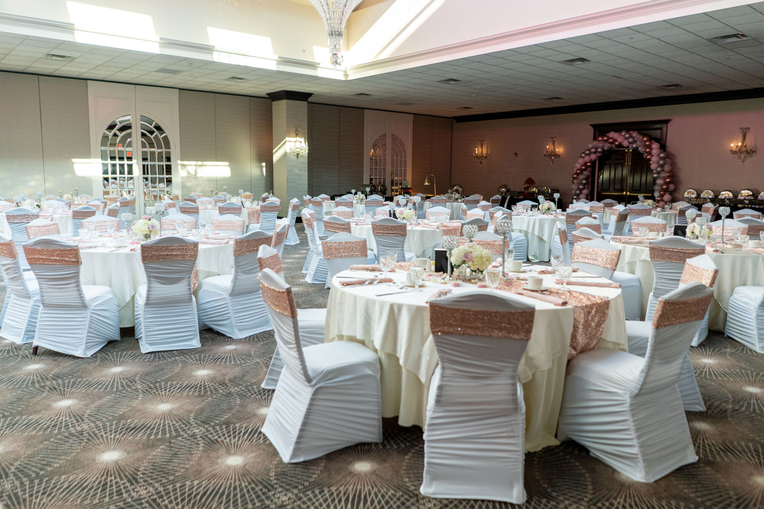 Elegant event hall with decorated tables and chairs.