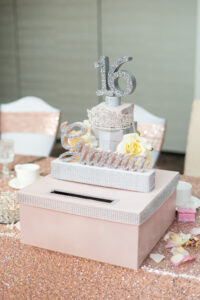 Elegant 16th birthday cake and gift box display.
