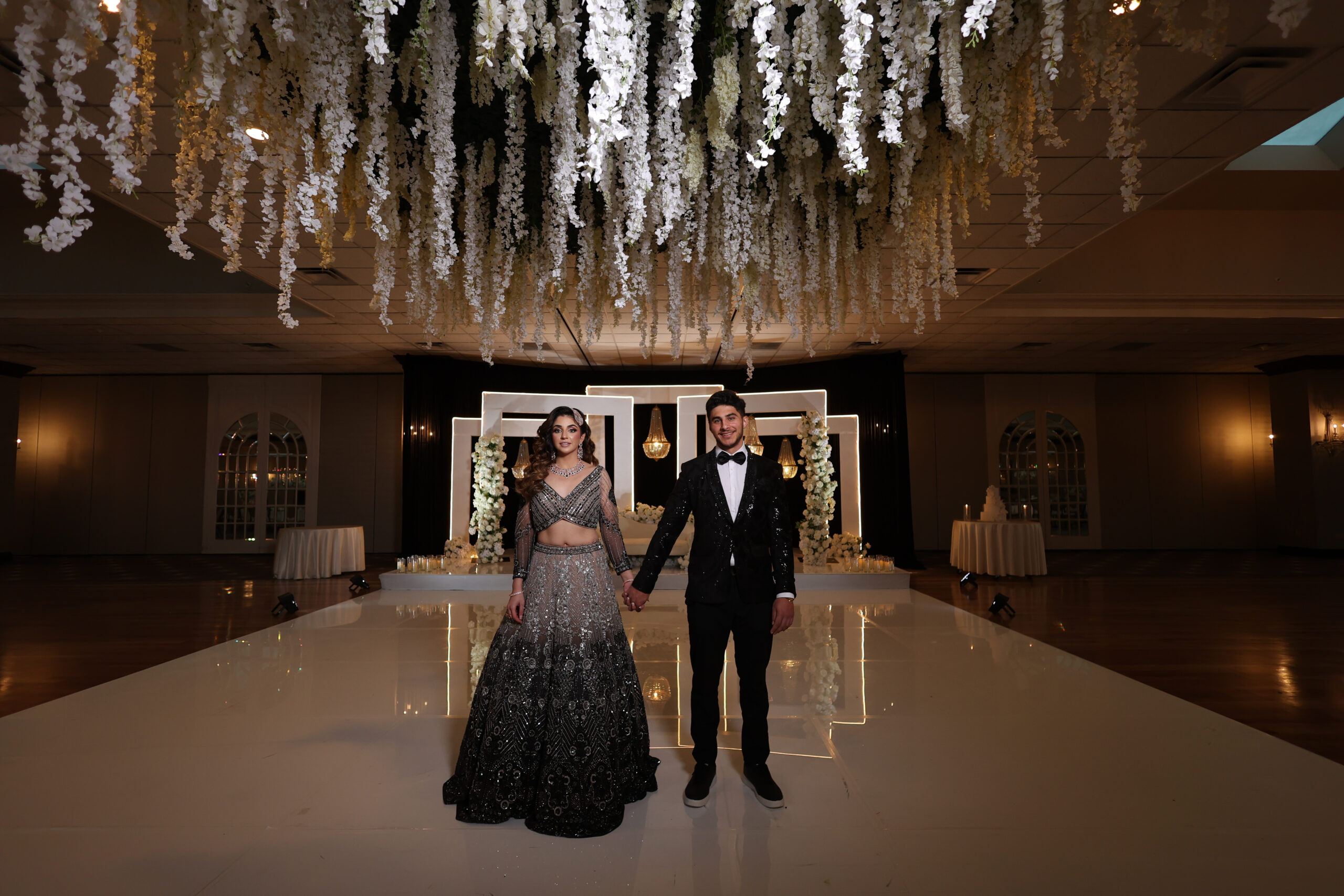 Couple under floral wedding decor.