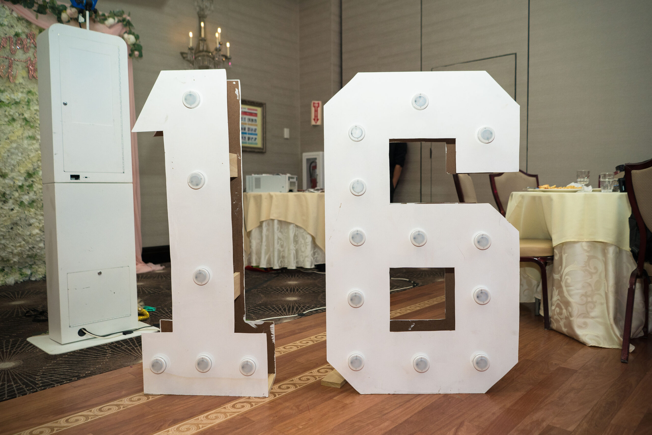 Large illuminated number 16 at an event venue.