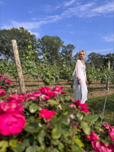 Woman in vineyard with roses in foreground