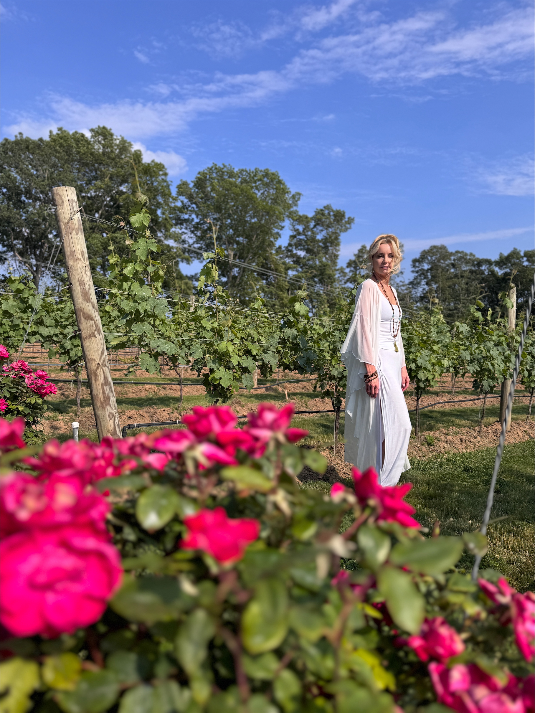 Woman in vineyard with roses in foreground