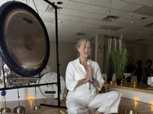 Woman meditating with sound bowls and candles.