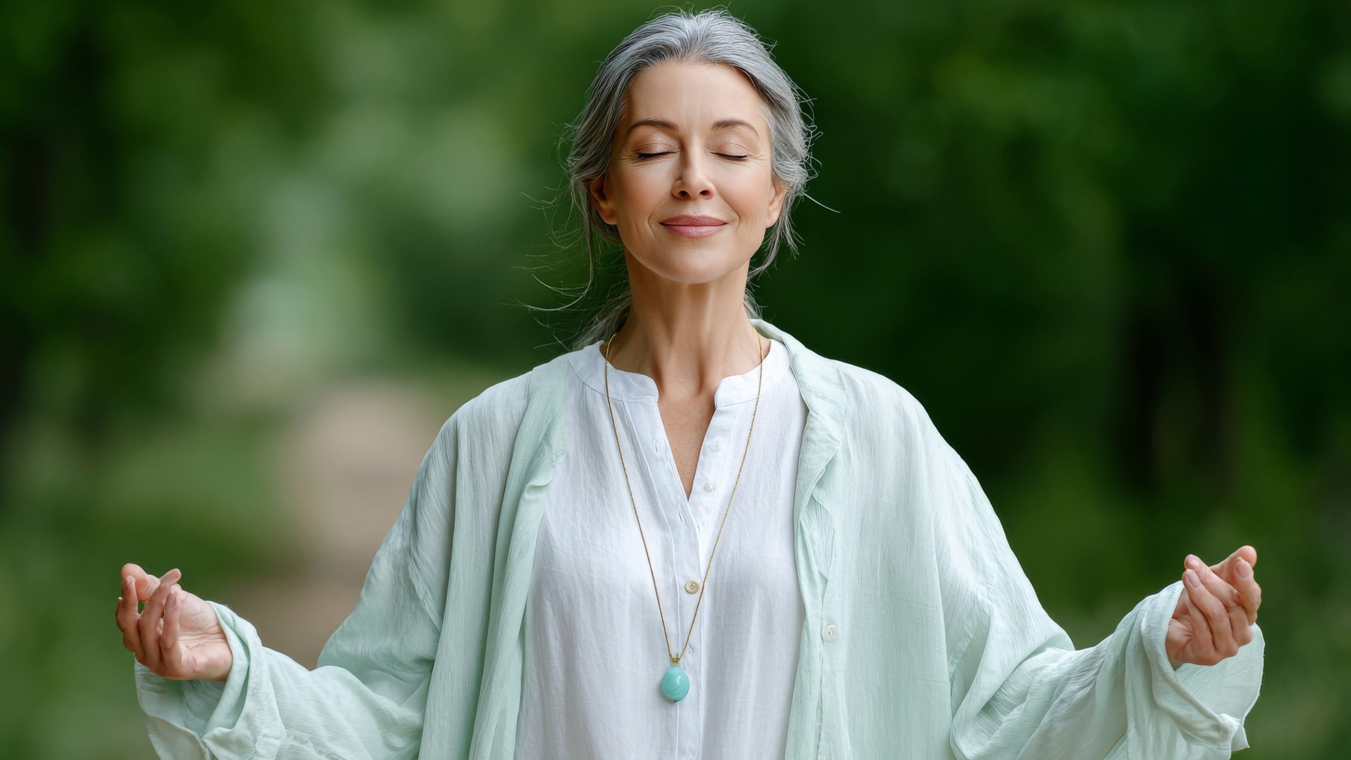 Woman meditating outdoors, eyes closed.